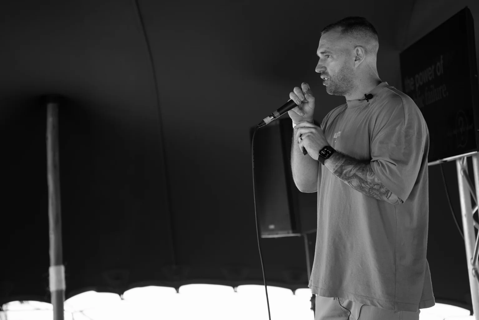 Aaron speaking into a microphone at an event